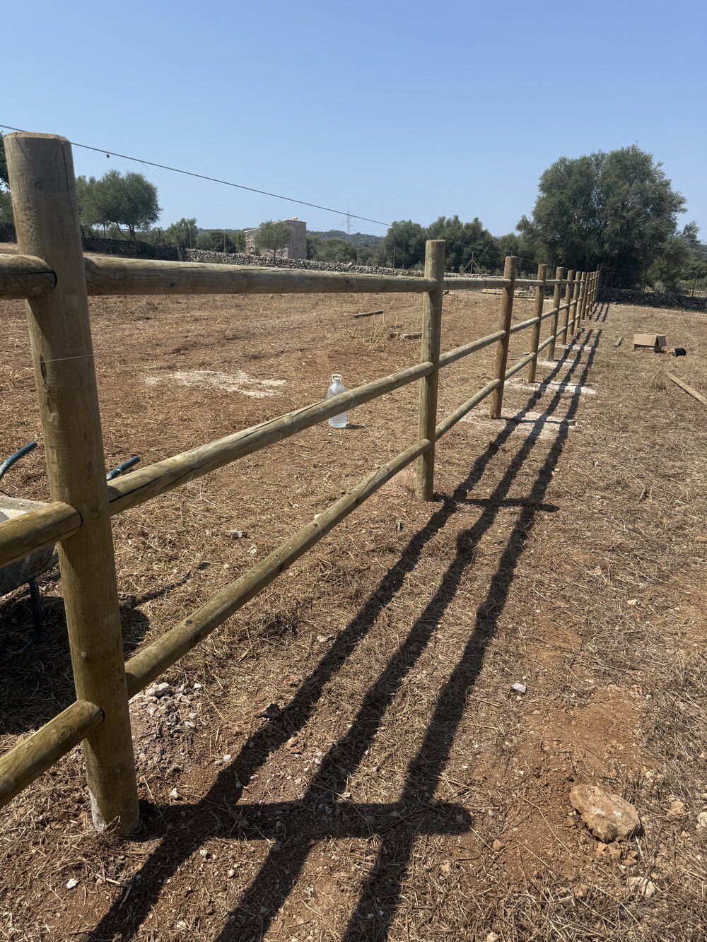 Detalle de barandillas de madera ancladas a doble poste en un cercado