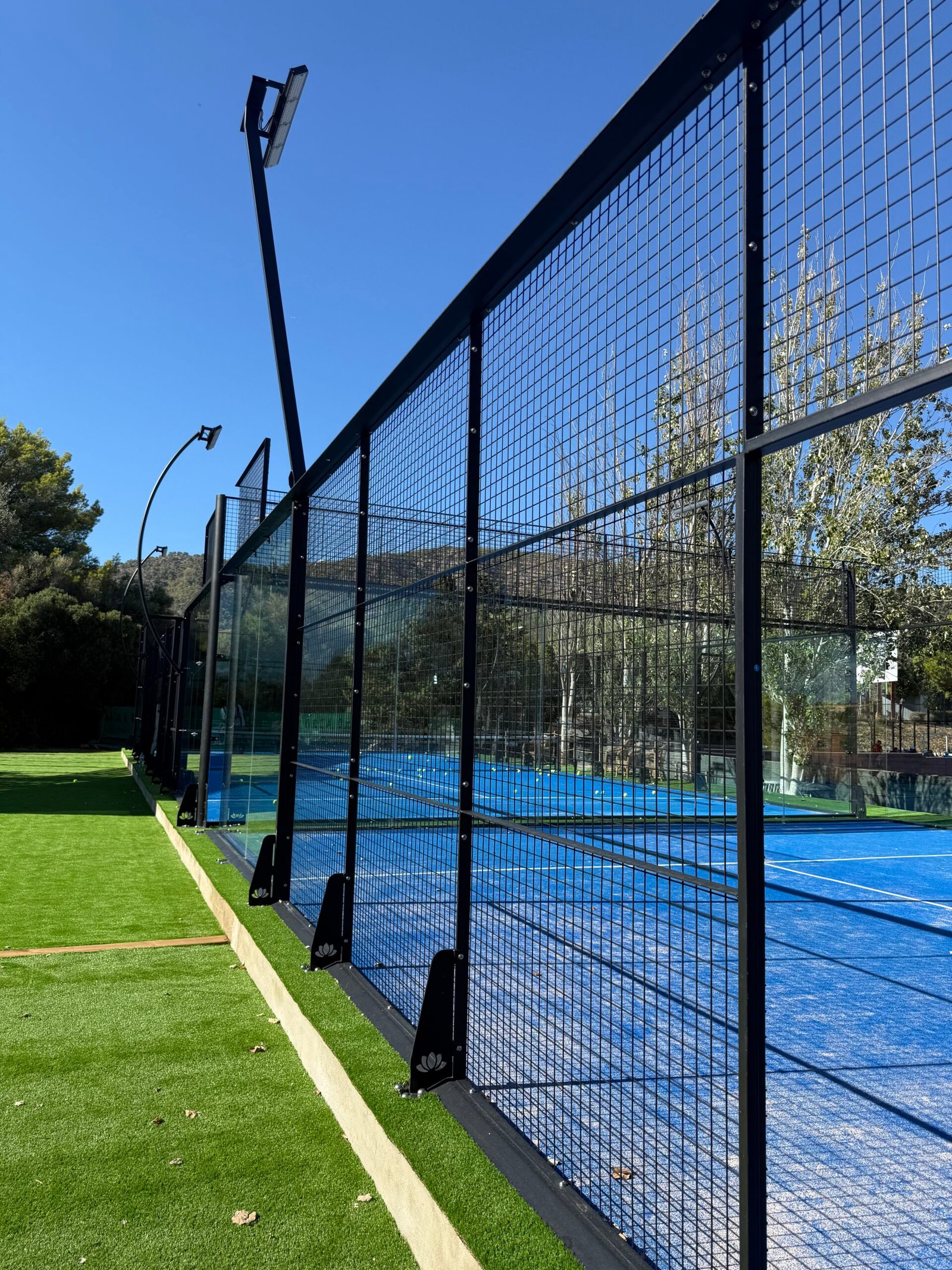 Pista de pádel con césped verde en entorno rural