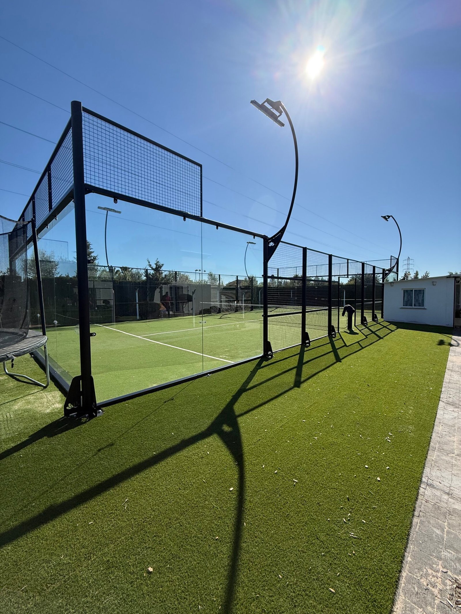 Pista de pádel con estructura de cristal, vista a contraluz