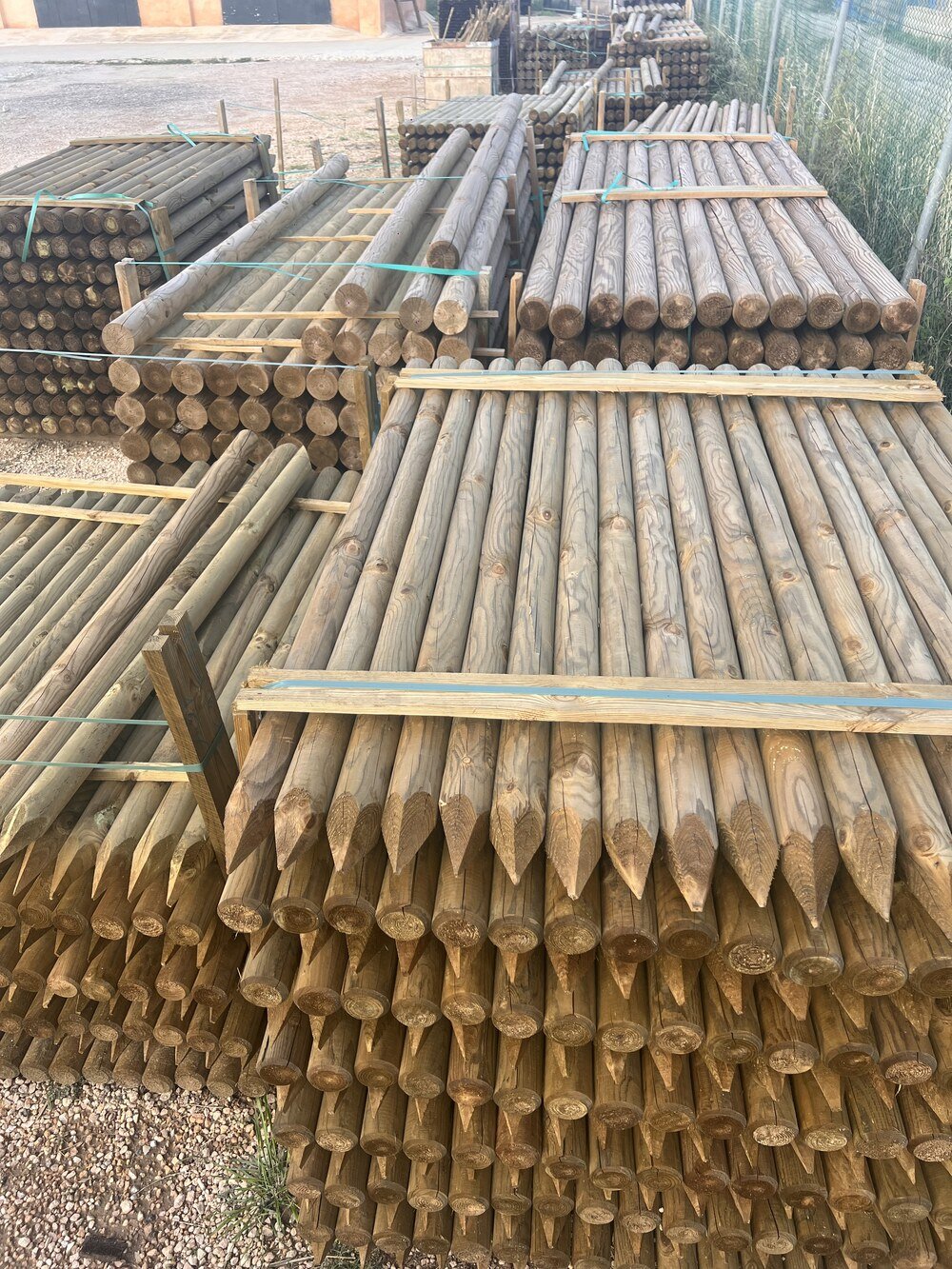 Variedad de postes de madera apilados en el patio