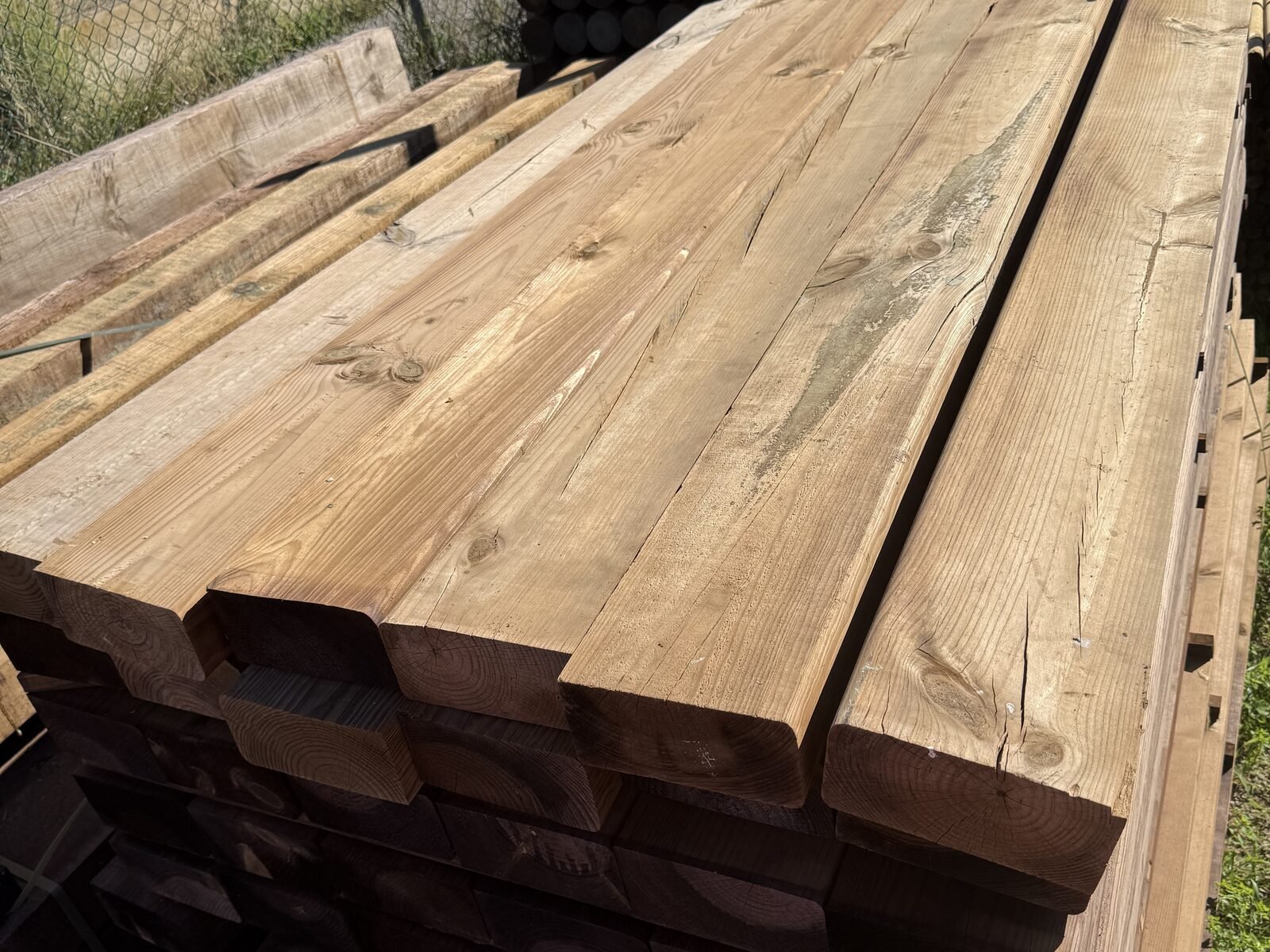 Vigas de madera nueva apiladas en el almacén