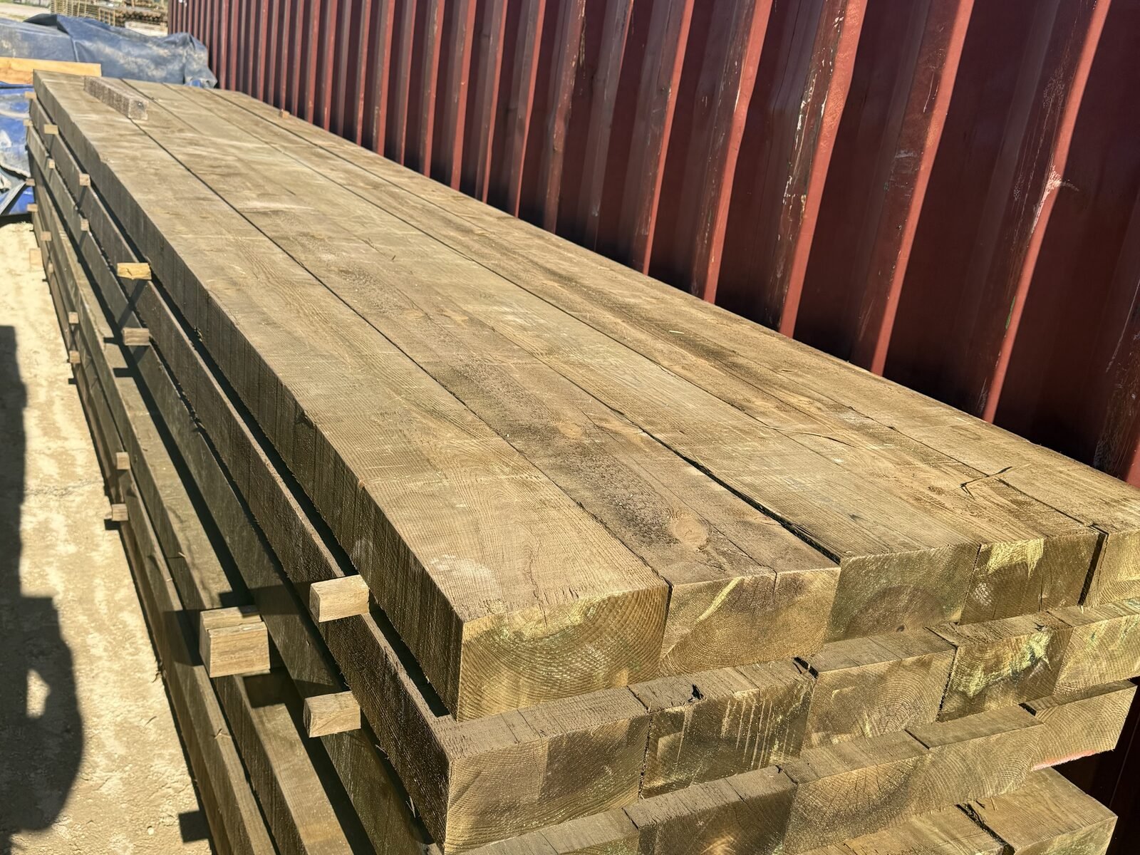 Vigas de madera junto a contenedor de transporte