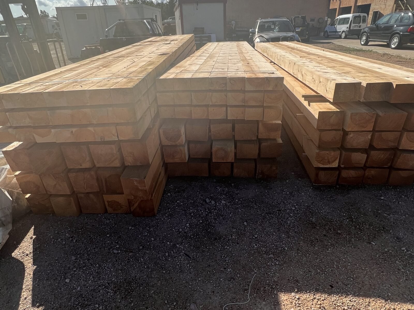 Vigas de madera apiladas junto a la valla del patio