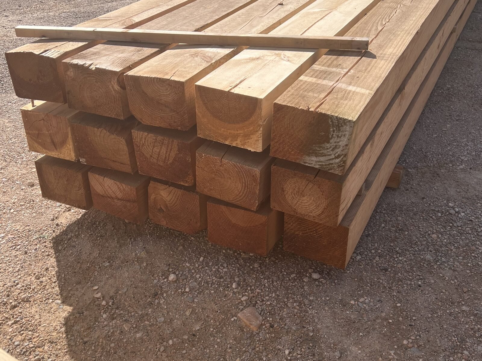 Vigas de madera tratada de tono oscuro apiladas